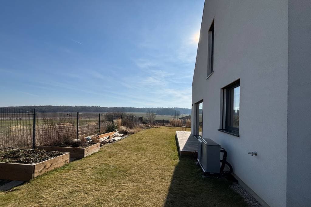 A real yard before: plain lawn, raised beds, and a bare fence